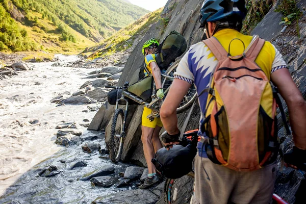 Ciclista de montaña está cruzando el río en las tierras altas de Tusheti —  Fotos de Stock