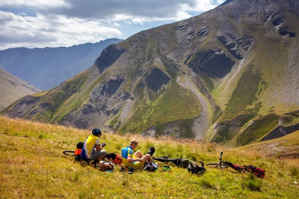 Ciclistas descansam nas montanhas enquanto pedalam — Fotografia de Stock