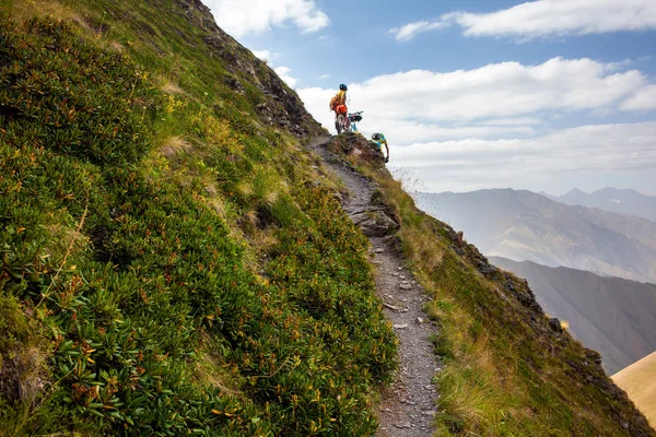 Motociclista empurra sua bicicleta em altas montanhas do Cáucaso — Fotografia de Stock