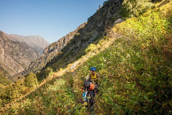 Motociclista empuja su bicicleta en las altas montañas del Cáucaso —  Fotos de Stock