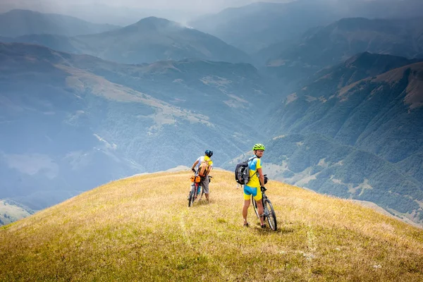 Los ciclistas descansan en las montañas mientras andan en bicicleta —  Fotos de Stock