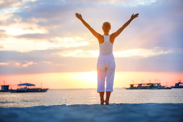 En kvinna gör yogaövningar på solnedgången på Boracay island, — Stockfoto