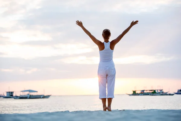 En kvinna gör yogaövningar på solnedgången på Boracay island, — Stockfoto