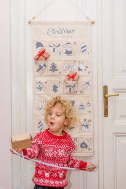 Çocuk geliş takviminden bir hediye açar