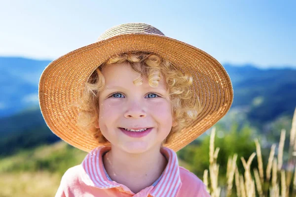 Хлопчик в солом'яному капелюсі влітку — стокове фото
