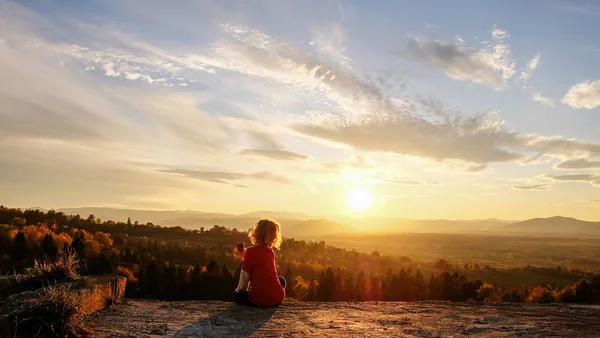 O menino gosta do pôr do sol nas montanhas — Fotografia de Stock