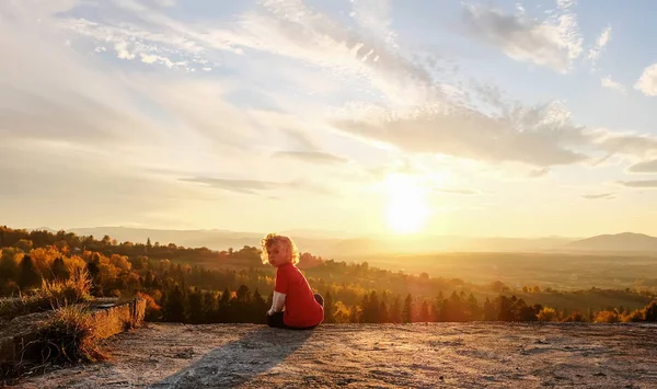 El niño disfruta de la puesta de sol en las montañas — Foto de Stock