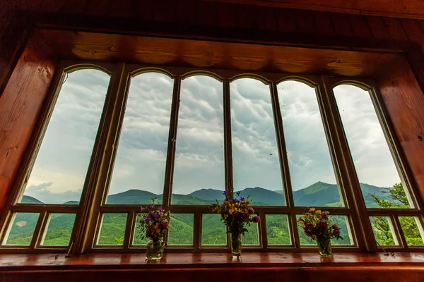 Campo de verão e montanhas vistas pela janela — Fotografia de Stock
