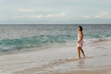 Gün batımında okyanusun kenarında güzel bir kadın