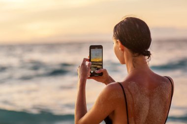 Gün batımında okyanusun kenarında güzel bir kadın