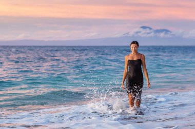 Gün batımında okyanusun kenarında güzel bir kadın