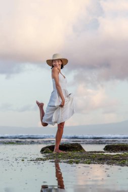 Gün batımında okyanusun kenarında güzel bir kadın