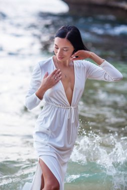 Gün batımında okyanusun kenarında güzel bir kadın