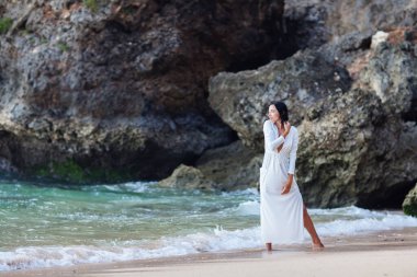 Gün batımında okyanusun kenarında güzel bir kadın