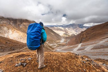 Yürüyüşçü Himalaya dağlarının manzarasının tadını çıkarıyor.