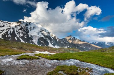 Bulutlu bir günde dağların arasında yeşil göl
