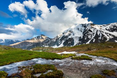 Bulutlu bir günde dağların arasında yeşil göl