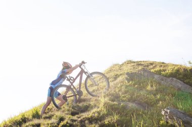 Güzel yeşil ormanda bisiklet süren bir kadın. Macera, bisiklet.