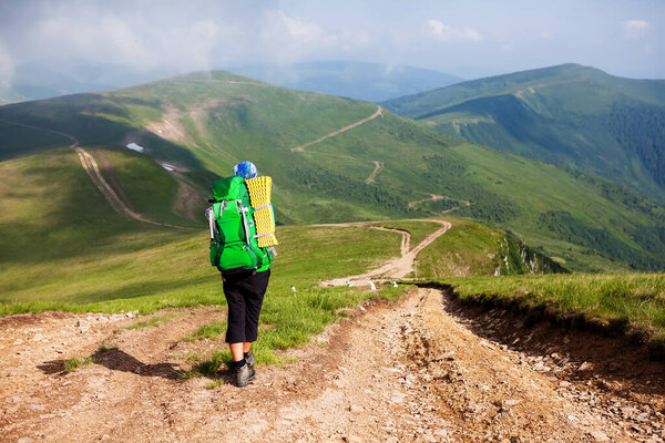 Young people are hiking in Carpathian mountains in summertime