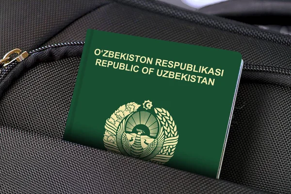 Primer plano del pasaporte de Uzbekistán en el bolsillo de la maleta negra —  Fotos de Stock