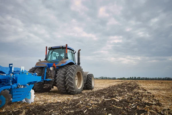 Traktor pracuje v terénu — Stock fotografie