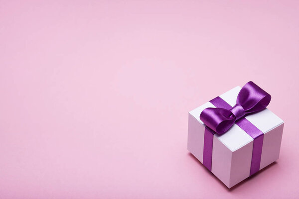 Box with a gift on pink background