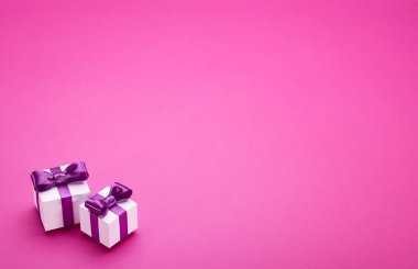 Pembe üzerinde saten yay ile hediyeler