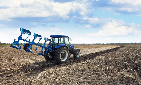 Agricultural tractor with plow — Stock Photo, Image