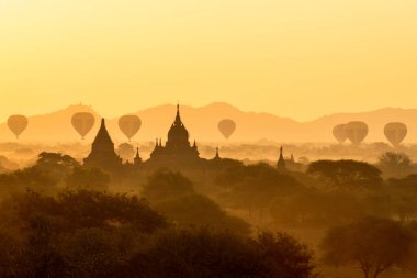 Myanmar 'da Bagan' ın üzerinde birçok sıcak hava balonuyla manzara ve çarpıcı gün doğumu. Bagan, binlerce tarihi Budist tapınağına sahip UNESCO tarafından onaylanmış antik bir şehir ve Dünya Mirası Alanıdır.