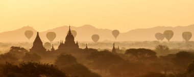 Myanmar 'da Bagan' ın üzerinde birçok sıcak hava balonuyla manzara ve çarpıcı gün doğumu. Bagan, binlerce tarihi Budist tapınağına sahip UNESCO tarafından onaylanmış antik bir şehir ve Dünya Mirası Alanıdır.