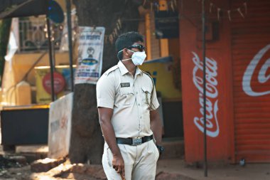 Hindistan, GOA, Arambol, Polis (CRPF) personeli, COVID-19 Coronavirus 'a karşı tedbir olarak Hindistan' ın tecrit ve sokağa çıkma yasağı süresince durduruldu ve kontrol altına alındı