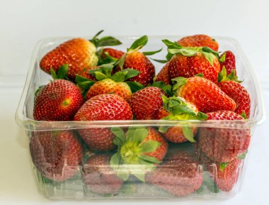 Beyaz arka planla çevrili birkaç çilek.