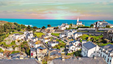 Luarca village in Asturias in the north of Spain in a cloudy day clipart