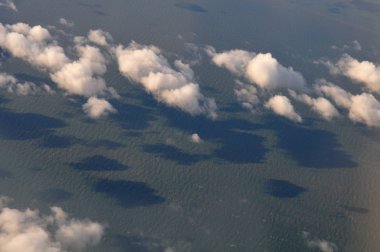 Bulutlar dalgalı su yüzeyine gölge düşürüyor