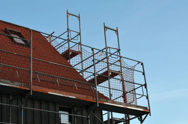 Czerwona siatka bezpieczeństwa na rusztowaniu na dachu — Zdjęcie stockowe