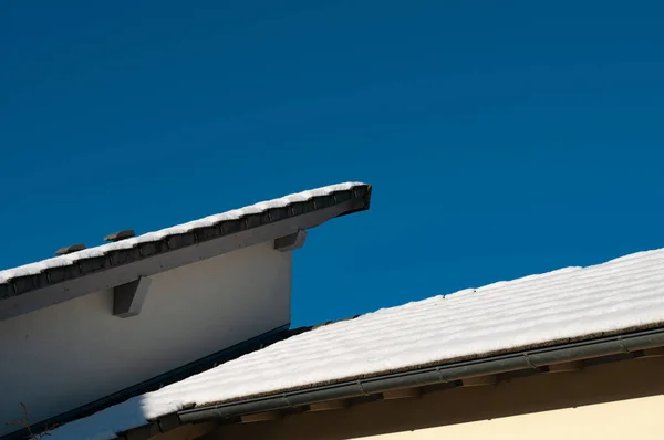 Güneşli Bir Kış Gününde Modern Bir Binanın Sarsıcı Çatısı Karla — Stok fotoğraf