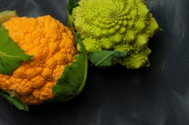 Gri arkaplanda bir portakal ve bir Romanescu karnabaharı