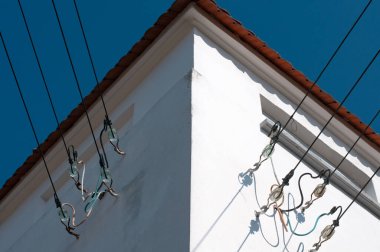 Elektrik dağıtım kabloları güneş ışığında cam yalıtımlı bir istasyonun ön cephesine sabitlenmiş.