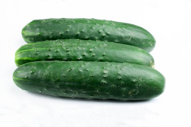 Beyaz arka planda üç organik yetiştirilmiş yeşil salatalık.