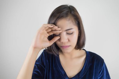 Kadın hasta ve kafasını tutarak. Baş ağrısı.