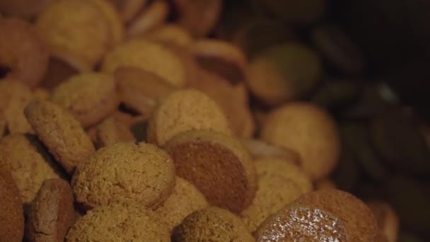 Ciasteczka poruszają się po linii przenośnika. Ciasteczka owsiane są brązowe. Produkcja żywności przemysłowej, cukiernia lub piekarnia — Wideo stockowe