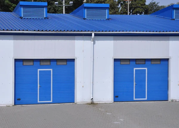 Puertas de lamas de color azul en la entrada del edificio del almacén . — Foto de Stock