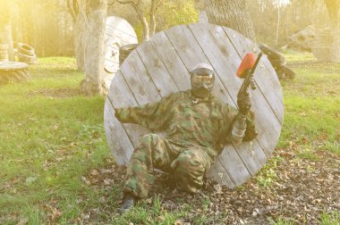 Koruyucu üniformalı bir paintball oyuncusu ve bir orman davasında maske takan bir kurban arıyor.