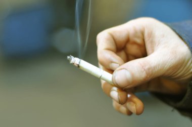 Fabrikadaki adam sigara içiyor. Yumuşak bulanıklık, bulanıklık