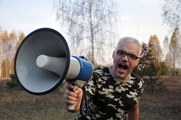 Portret młodego mężczyzny krzyczącego do megafonu. — Zdjęcie stockowe