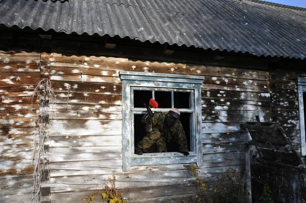 Aktives Paintballspiel. Dekoration des Spielfeldes, ein Holzhaus dient als Unterschlupf für den Spieler. — Stockfoto