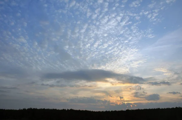 Belo pôr do sol com nuvens vermelhas brilhantes e raios de sol. Abstrato . — Fotografia de Stock