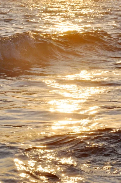 Tropische zonsondergang achtergrond. Prachtige kleurrijke Oceaan Golf breken sluiten in de buurt van zandstrand. Verblinding op het water — Stockfoto