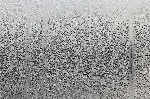 젖은 유리 위에 물 한 방울. 얼음이 녹아내리고 얼음 이 창문에 떨어져. — 스톡 사진