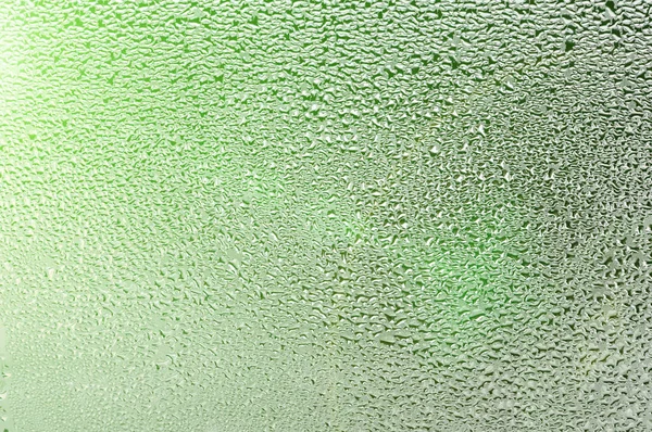 Gotas de agua en el vaso mojado. Descongelar, derretir, hielo en la ventana . —  Fotos de Stock